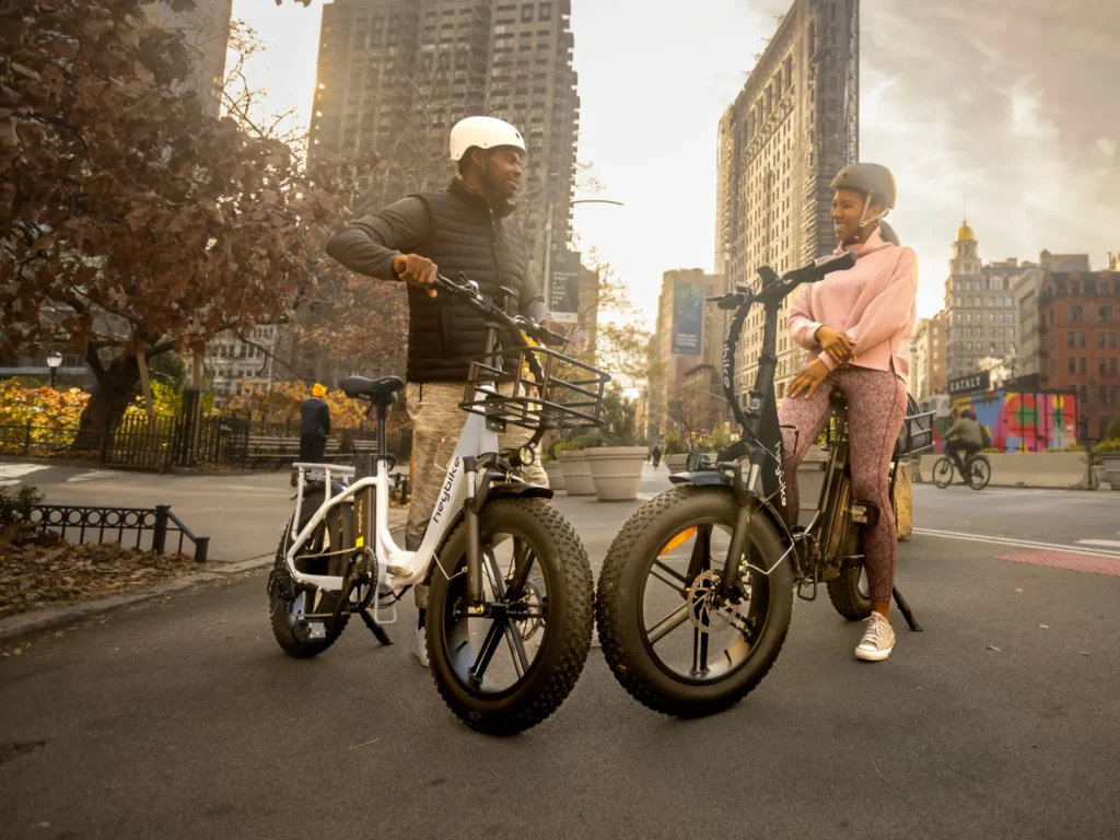 People on electric bikes, stopped on a city street, talking to one another